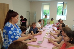 Uczestnicy ŚDS podczas warsztatów ceramicznych i linorytu, praca w glinie