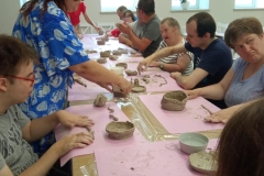 Uczestnicy ŚDS podczas warsztatów ceramicznych i linorytu, praca w glinie